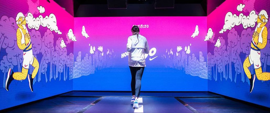 woman running surrounded by LED screens