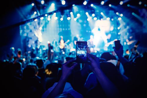 Man takes a picture of the show at the concert hall