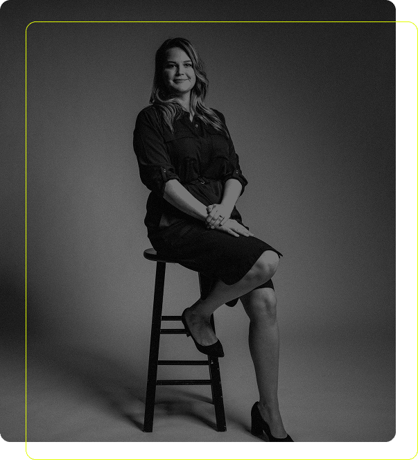 Professional woman sitting on stool during corporate event portrait session
