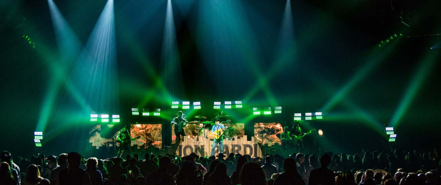 Live event production with green stage lighting and LED video wall for corporate presentation