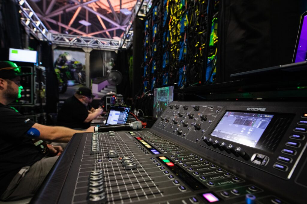Sound engineer adjusting audio control panel backstage.