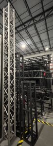 Warehouse stacked with metal truss structures for events.