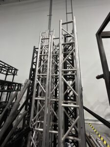 Metal trusses stacked in a warehouse for event setup preparation.