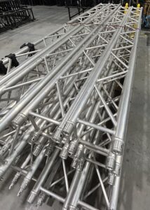 Stacked aluminum stage trusses in storage.