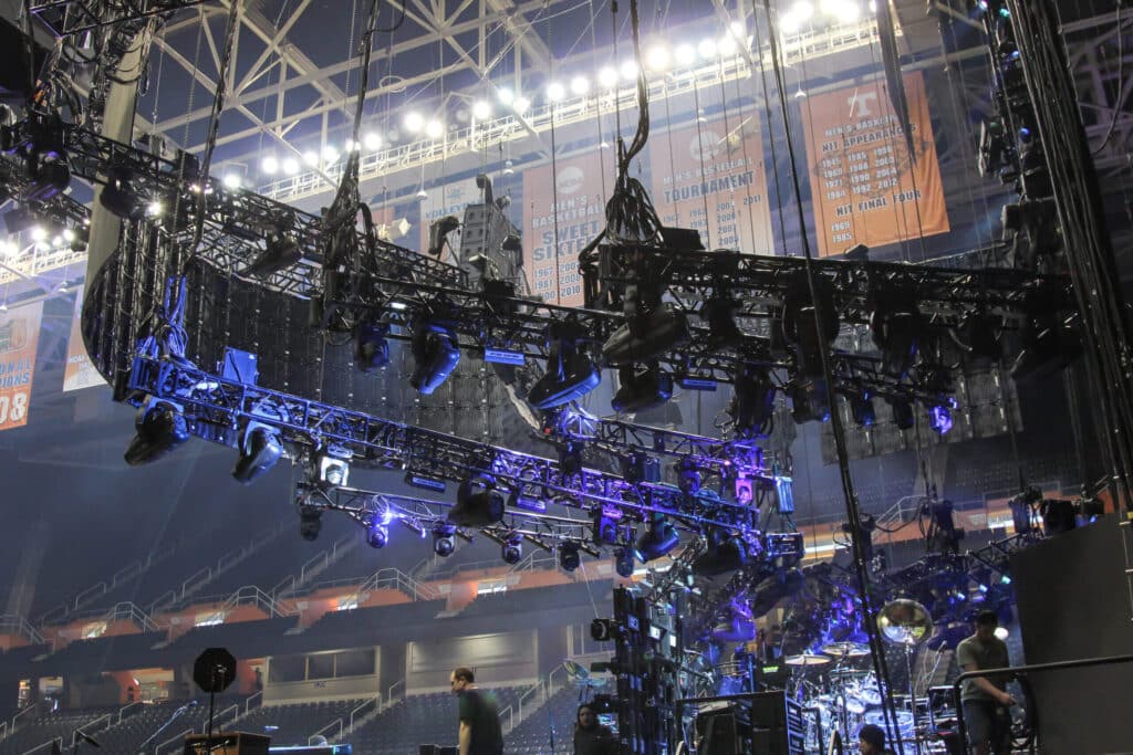 Complex lighting rigging and truss system suspended over corporate event venue setup