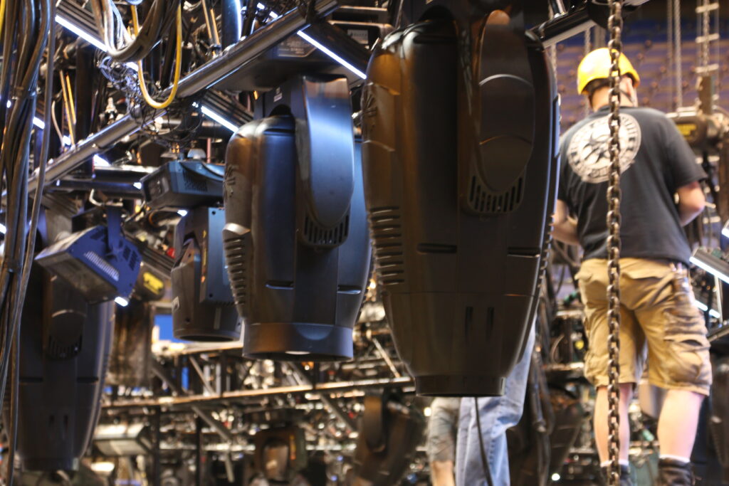 Stage lighting setup with technician preparing equipment.