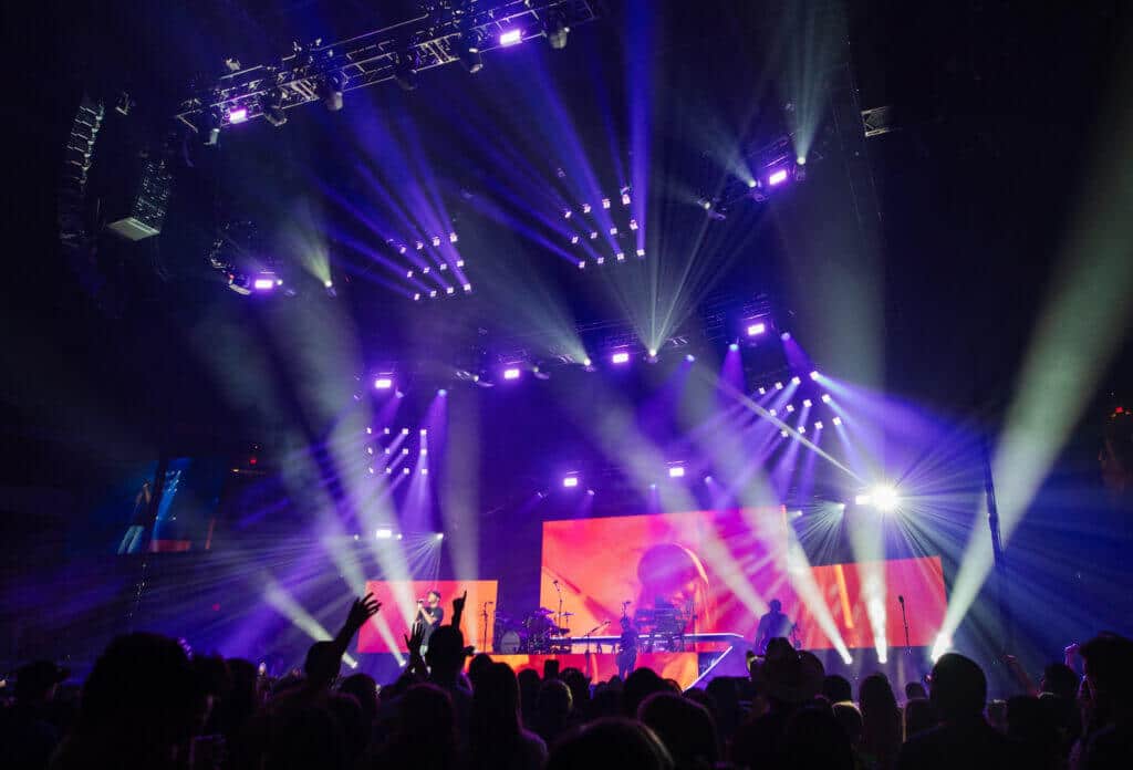 Concert stage with purple lighting design and LED backdrop during live performance