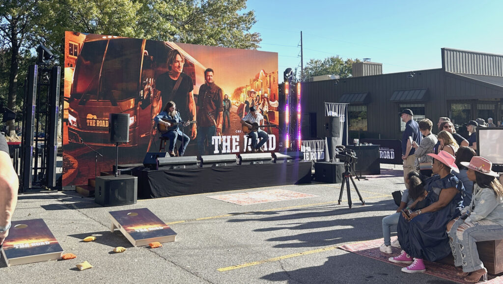 Live outdoor concert stage with LED video wall and performers during corporate event production