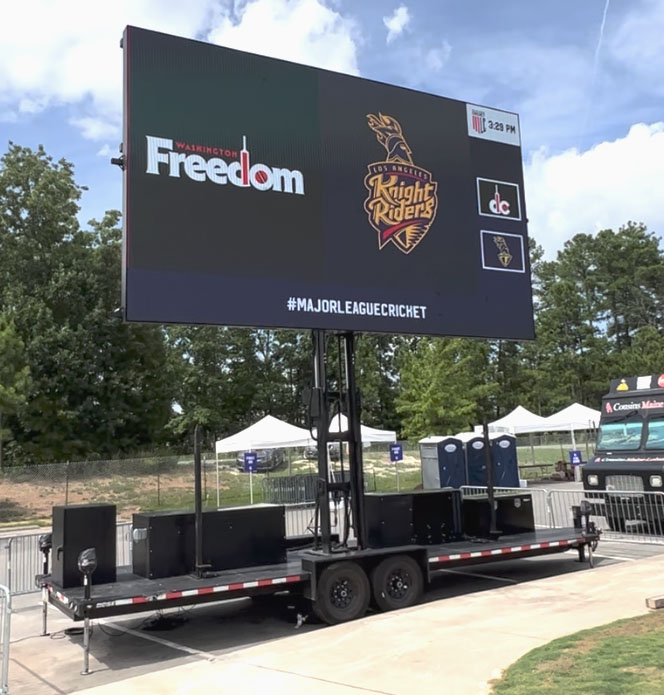 Mobile LED scoreboard on trailer displaying Kolkata Knight Riders branding at outdoor cricket venue